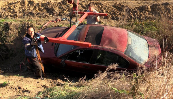 BMW i Mazda w rowie, śmieciarka na ruchliwej trasie